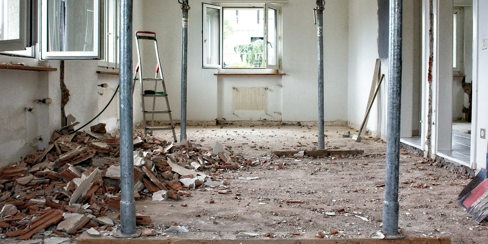 This image captures a critical structural phase of a professional home flip, where a traditional layout is being transformed into a modern, open‑concept living space.